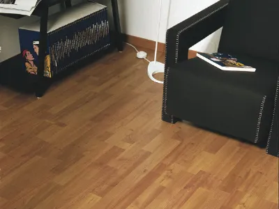 dettaglio laminato in legno chiaro con poltrona nera e scaffalatura